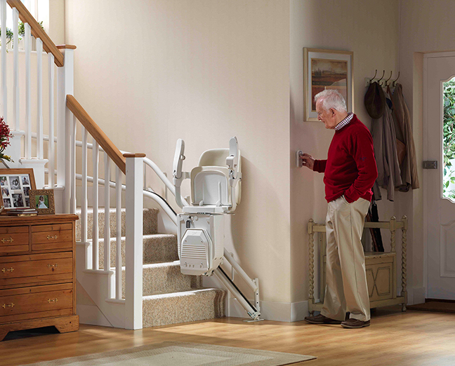 senior man calling a stairlift using a remote control
