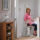 Woman on a Stannah stairlift at the top of the stairs on the first floor of the house